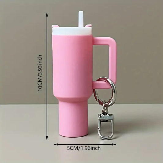 Mini pink silicone cup with straw and keychain on a gray background